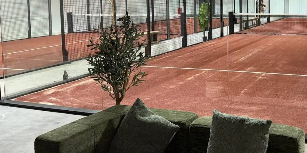 The café sofas beside the glass wall of the double court