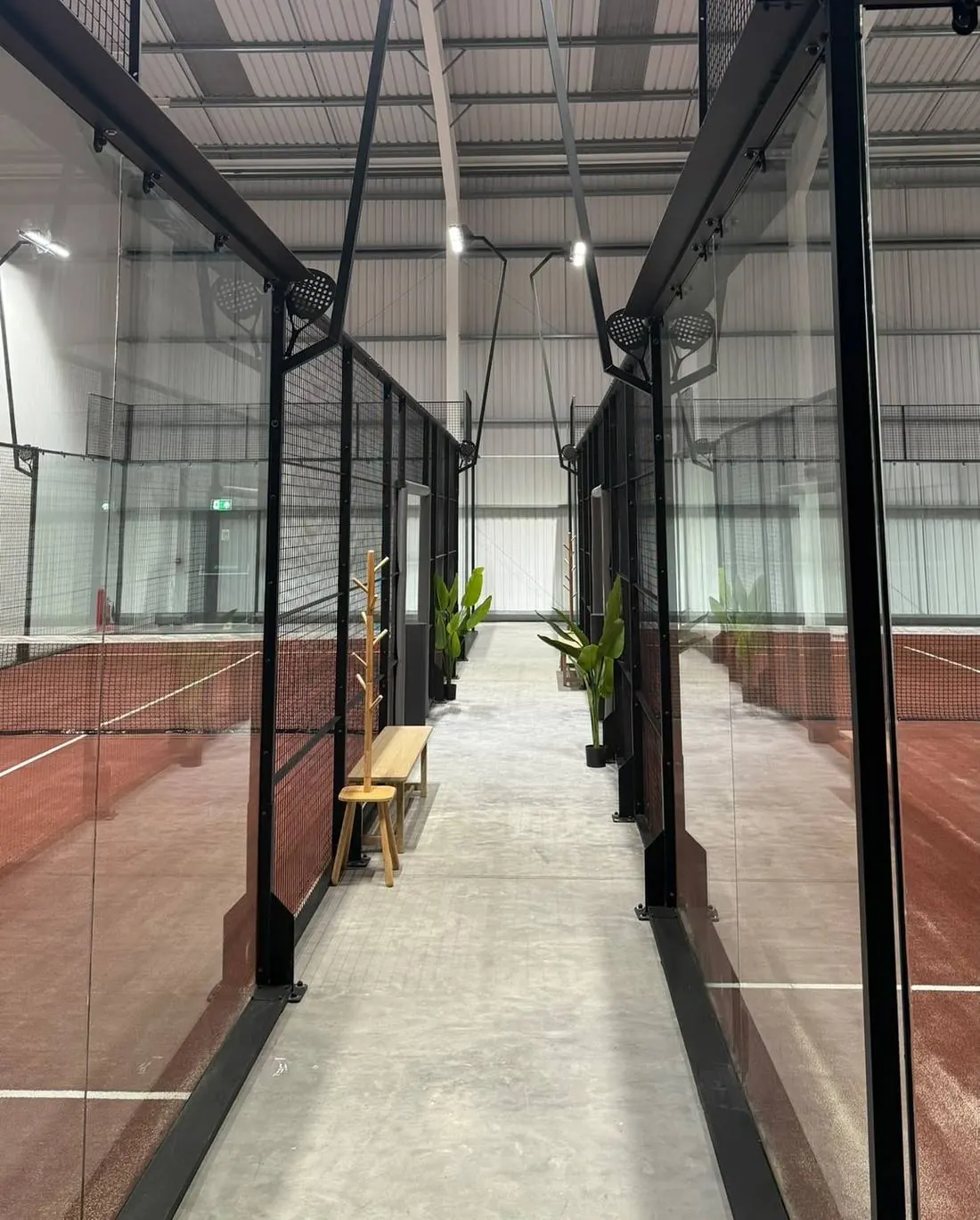 Looking down the walkway between the glass courts at PADELPRIV